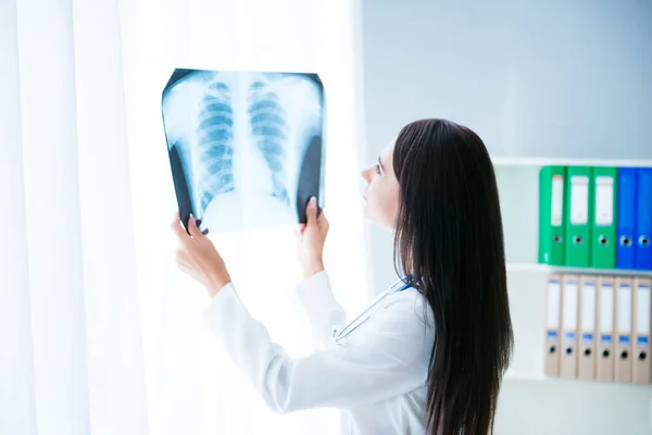 Médico femenino mirando la imagen de rayos X del pulmón de la paciente — Foto de Stock