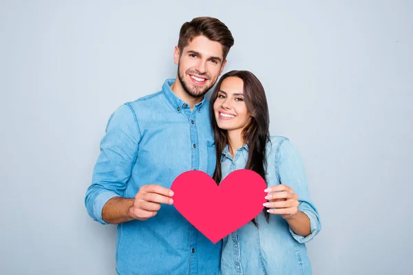 Joven feliz pareja enamorada sosteniendo el corazón de papel rojo — Foto de Stock