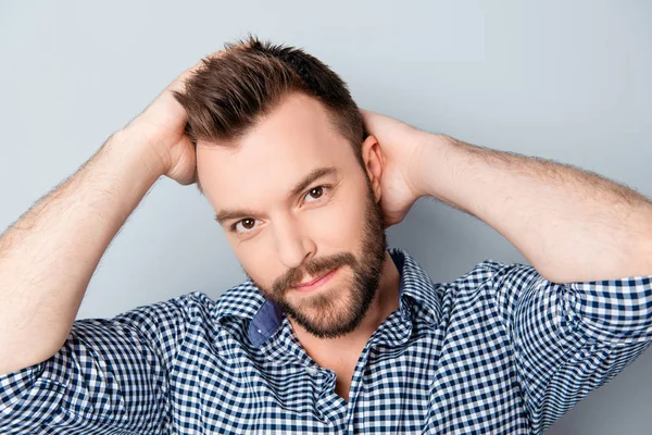 Handsome smiling man holding hands on his hair — Stock Photo, Image