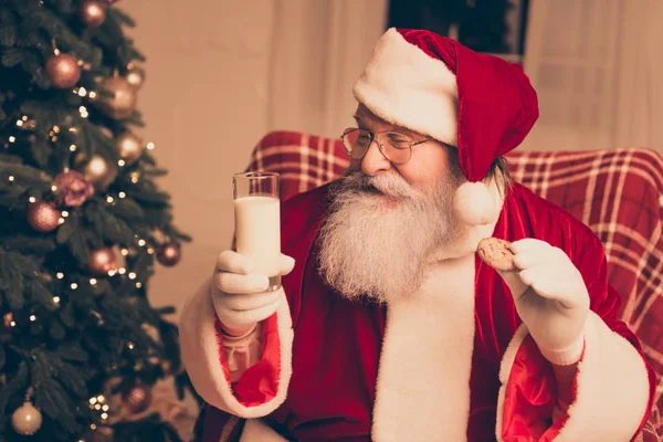 Glad Santa Claus sitting on chair in living room near christmas — Stock Photo, Image