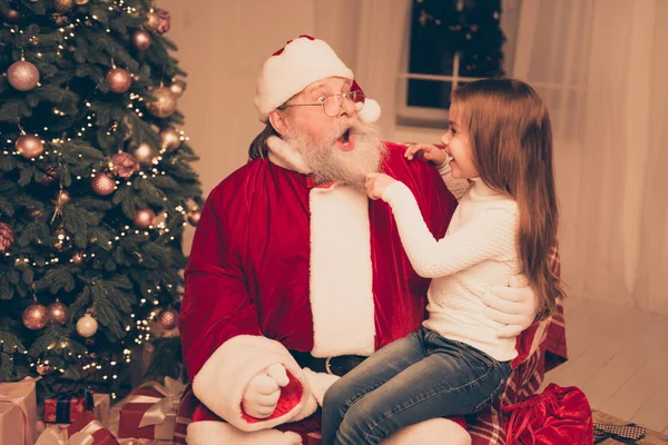 Menina esperta sentada no colo do velho Papai Noel e puxando h — Fotografia de Stock