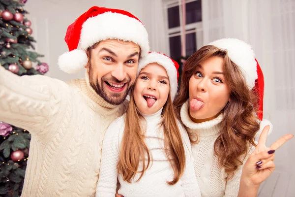 Família alegre fazendo cômico xmas selfie e mostrando línguas — Fotografia de Stock