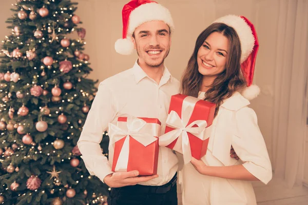 Feliz jovem casal celebrando o Natal e segurando prese vermelho — Fotografia de Stock