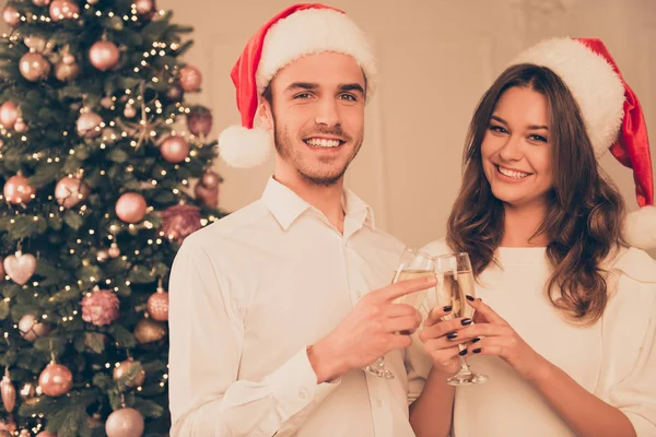 Mladí lidé v červené santa klobouky slavit Vánoce s champagne — Stock fotografie