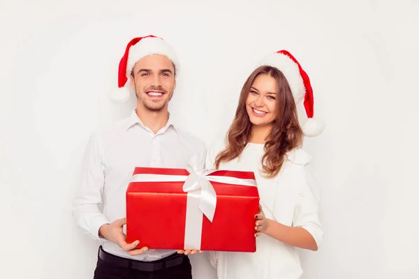 Feliz hombre y mujer sosteniendo gran regalo de Navidad rojo — Foto de Stock