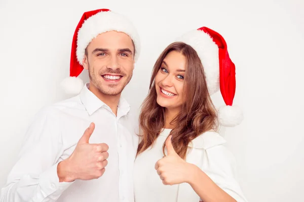 Pareja alegre en el amor en los sombreros rojos de santa gestos "COMO " — Foto de Stock