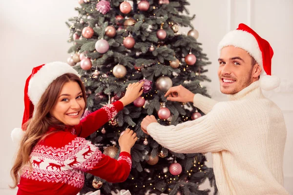 Portret van gelukkig vrolijke man en vrouw versieren kerst tr — Stockfoto