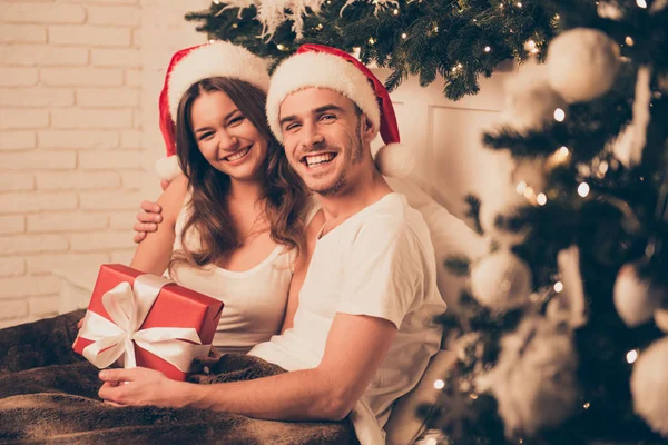 Joyeux souriant homme et femme couché dans le lit avec des cadeaux de Noël — Photo