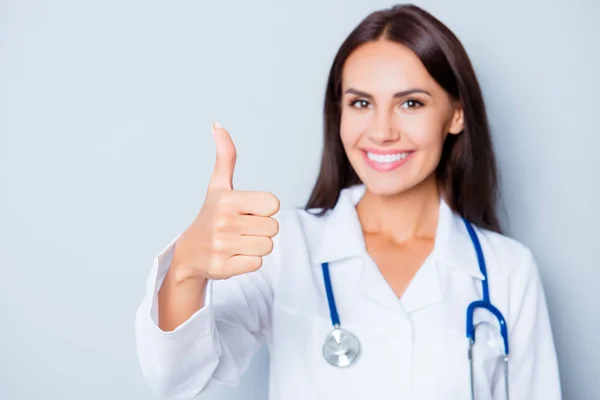 Médico muito smilind em uniforme branco mostrando polegar para cima — Fotografia de Stock