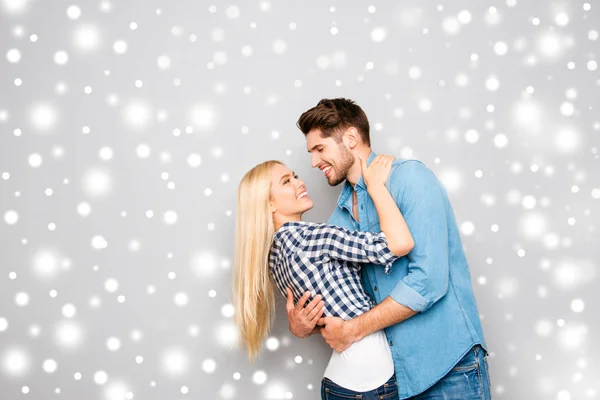 Feliz sorrindo jovens amantes abraçando no fundo de inverno nevado — Fotografia de Stock