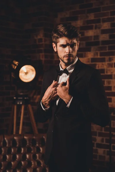 Retrato de homem elegante bonito em terno preto e laço — Fotografia de Stock