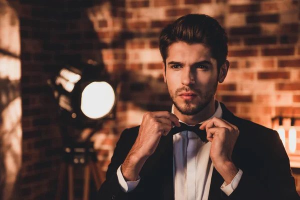 Portait of confident handsome man corecting his bow tie and wear — Stock Photo, Image