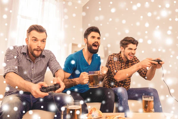 Nadšený veselá muži hrají videohry s pivem na vánoční svátky — Stock fotografie