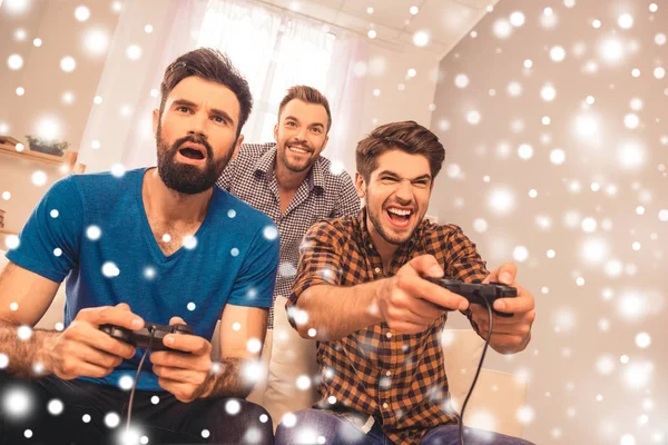 Tre migliori amici felici che giocano al videogioco su sfondo innevato — Foto Stock