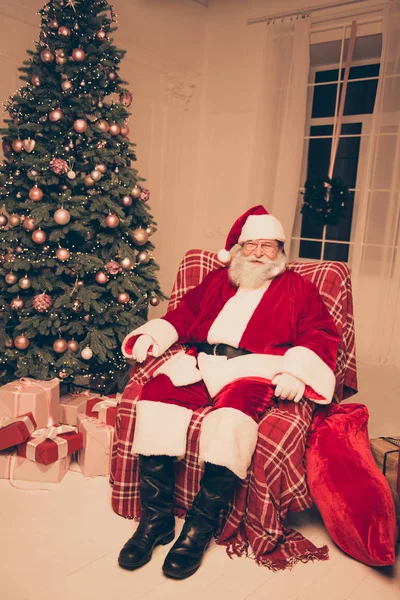 Velho Papai Noel em traje vermelho tradicional sentado em poltrona — Fotografia de Stock
