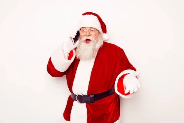 Der alte Weihnachtsmann im roten Kostüm plaudert auf dem Smartphone — Stockfoto