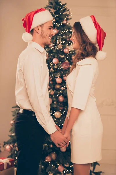 Side view portrait of cheerful man and woman in red santa hats h — Stock Photo, Image