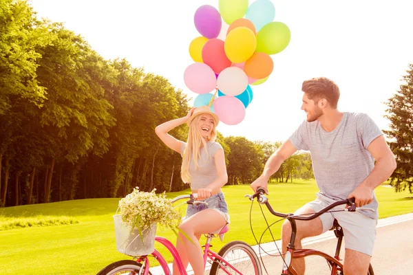 Hübsche lachende Frau mit Luftballons und Fahrrad — Stockfoto