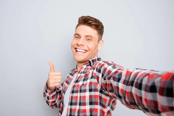 Bello allegro giovane uomo fare selfie e mostrando pollice in su — Foto Stock