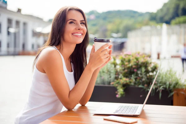 Happy young woman drinking coffe in a cafe and dreaming — Stock Photo, Image