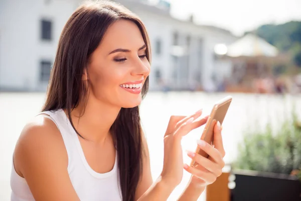 Aantrekkelijke vrolijke brunette vrouw wandeling en het typen van sms — Stockfoto