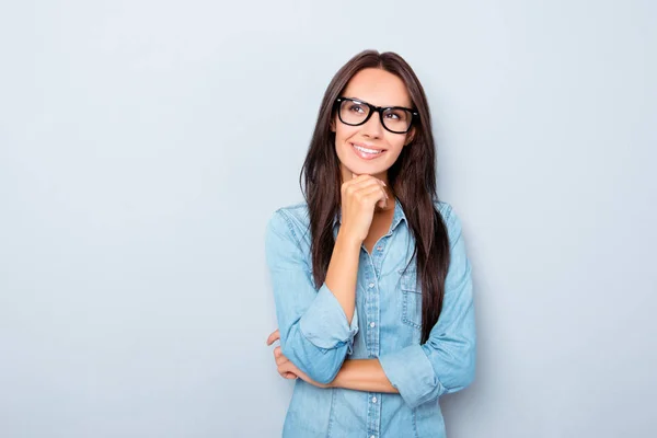 Joven secretaria reflexiva en gafas soñando sobre fondo gris — Foto de Stock