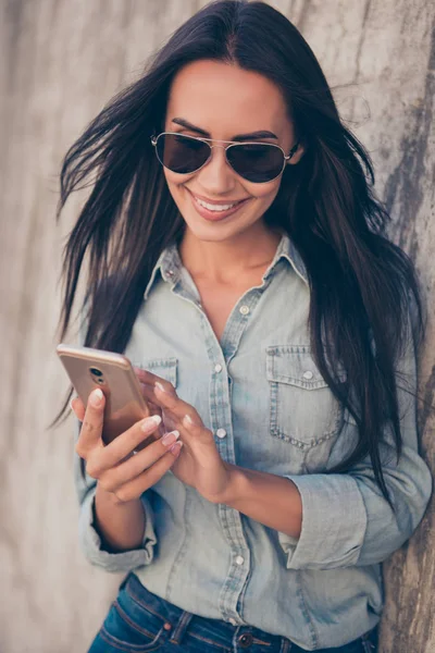 Retrato de mulher feliz em óculos digitando sms no smartphone e — Fotografia de Stock