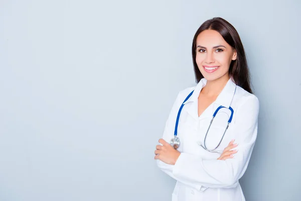 Fröhlich fröhlicher Arzt mit verschränkten Händen auf blauem Hintergrund — Stockfoto