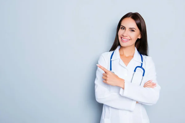 Sorrindo médico feliz apontando com o dedo no fundo azul — Fotografia de Stock