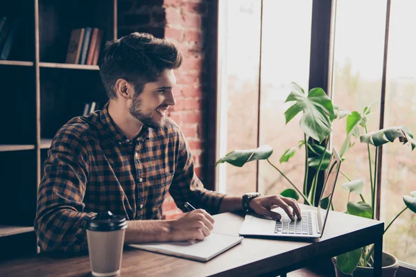 Empresário sorridente trabalhando com laptop e fazendo anotações — Fotografia de Stock