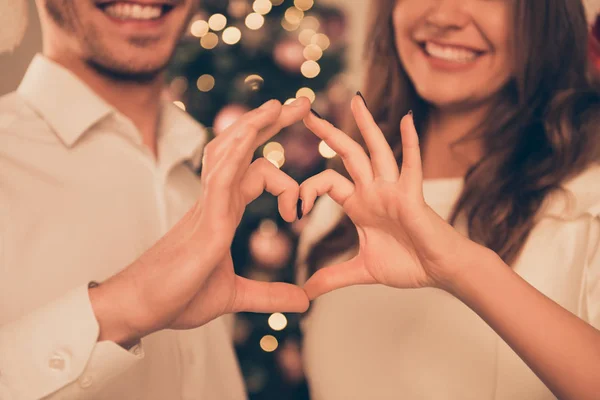 Close up of smiling man and woman making heart with fingers — Stock Photo, Image