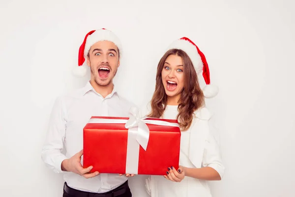 Páni! Vzrušený muž a žena držící velký vánoční dárek — Stock fotografie