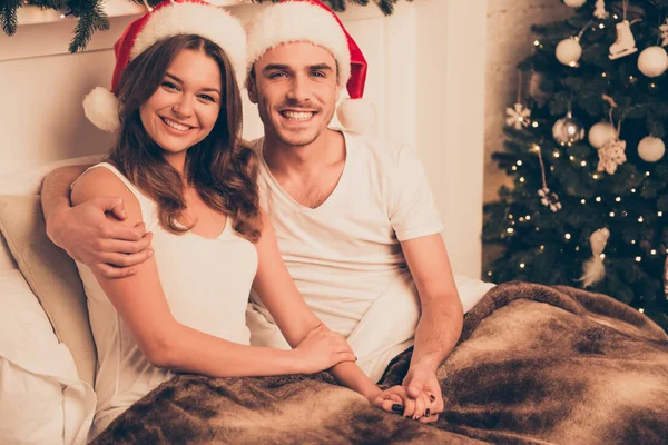 Bonito homem abraçando sua esposa na cama nos feriados de Natal — Fotografia de Stock