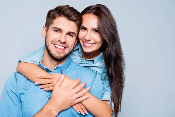 Retrato de amantes lindos felices abrazando sobre fondo gris — Foto de Stock