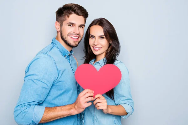 Portrait of young couple in love holding red paper heart — Stock Photo, Image