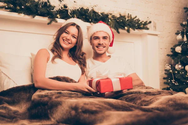 Manhã de Natal. casal feliz no amor deitado na cama com presente — Fotografia de Stock