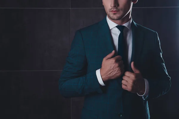 Close up de sério jovem empresário tocando seu terno — Fotografia de Stock