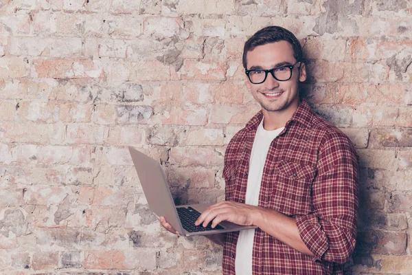 Счастливый молодой человек в очках с современным ноутбуком — стоковое фото