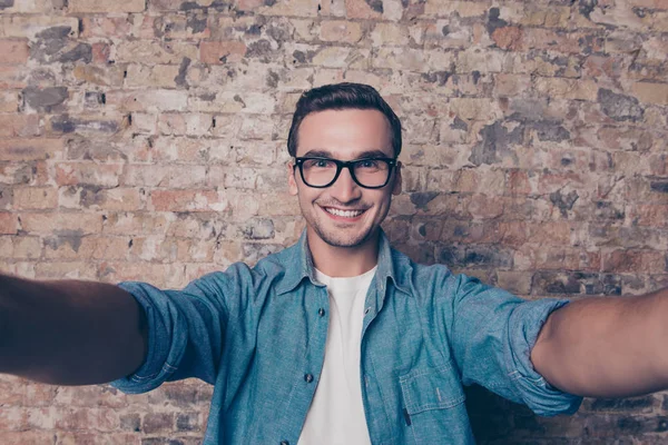 Красивый веселый улыбающийся мужчина в очках делает селфи — стоковое фото