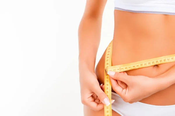 Close up  of slim woman measuring her waist's size with tape mea — Stock Photo, Image