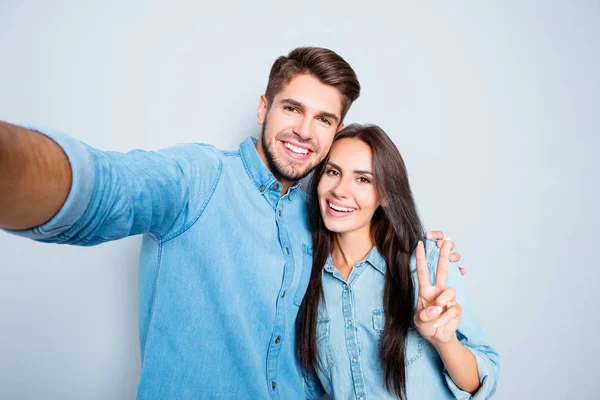 Bonito homem fazendo selfie com sua mulher bonita gesticulando v-sig — Fotografia de Stock