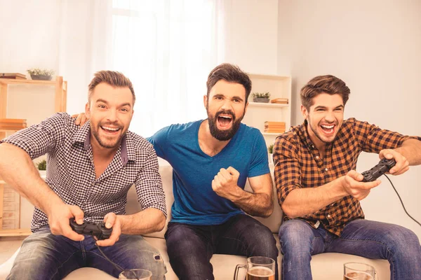 Портрет взволнованных смеющихся мужчин, играющих в видеоигры — стоковое фото