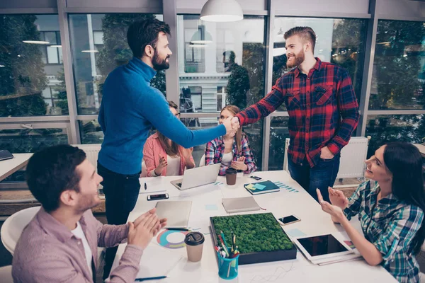 Forretningsfolk tar hverandre i hendene og avslutter et møte. – stockfoto