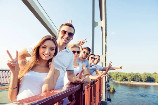 Skupina happy usměvavá přátel ukázal v-sign na mostě — Stock fotografie