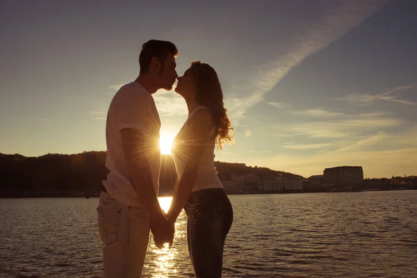 Silueta de pareja enamorada besándose y mirando al atardecer —  Fotos de Stock