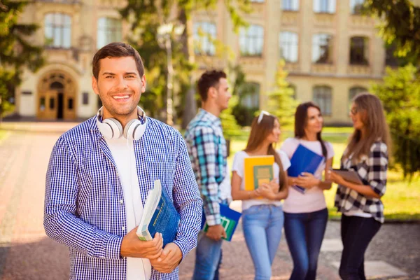 Glad ung man hålla böcker medan stående universitet ba — Stockfoto