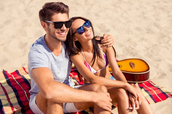 Krásný atraktivní pár sedí spolu na pláži s v — Stock fotografie