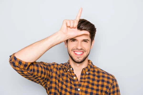 Lustiger junger Mann zeigt Zeichen eines Verlierers mit Fingern am Kopf — Stockfoto