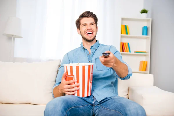 Hombre riendo viendo comedia y comiendo palomitas de maíz — Foto de Stock