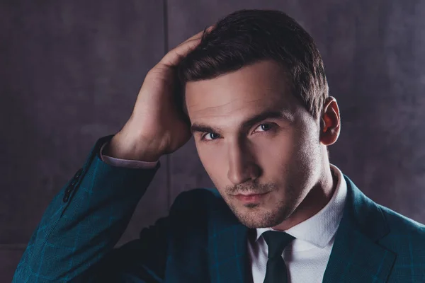 Handsome young man in black suit doing modern hairstyle — Stock Photo, Image